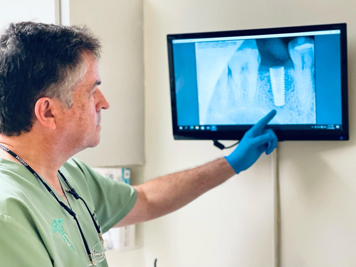 Dentist explaining digital tooth imaging on a monitor with a patient